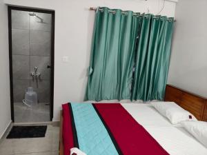 a bedroom with a bed and a glass shower at ElShium Homes in Cochin