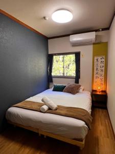 a bedroom with a large bed with a window at sneaky peaks in Hakuba