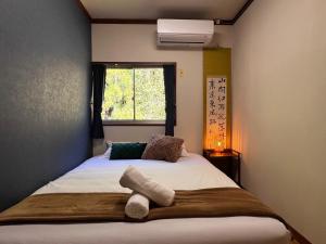 a small bedroom with a bed with a window at sneaky peaks in Hakuba