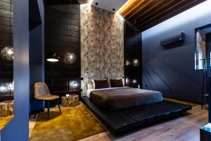 ein maskulines Schlafzimmer mit Bett und Stuhl in der Unterkunft ZEN & ART - Alojamento de Charme in Santa Maria da Feira + 76 Fotos