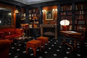 a living room with a fireplace and a red couch at Hotel d’Inghilterra Roma – Starhotels Collezione in Rome +172 photos