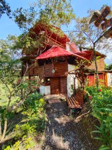 a wooden house with a red roof at Hospedaje casa en el Árbol in Moniquirá