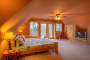 ein Schlafzimmer mit einem Bett und einem Fernseher in einem Zimmer in der Unterkunft Luxury Mountain Cabin Rental with a Hot Tub in Helen, Georgia in Helen