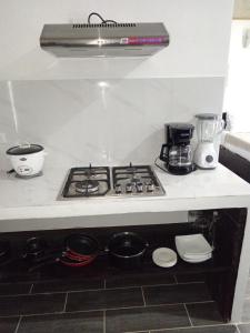 a kitchen with a stove top oven with pots and pans at Pino Longe, Río Celeste in Upala