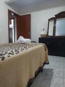 ein Schlafzimmer mit einem Bett mit Spiegel und einer Kommode in der Unterkunft My Espacinho in São Bento in São Bento do Sul