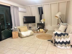 a living room with a couch and a tv at Tranquil Hideaway in Mudgeeraba in Gold Coast