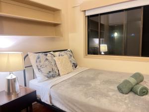 a bedroom with a large bed with a window at Tranquil Hideaway in Mudgeeraba in Gold Coast