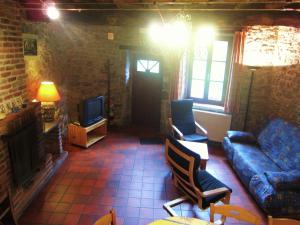 a living room with a couch and a tv at Riverside Retreat Viroinval in Treignes