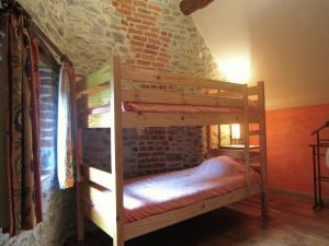 a wooden bunk bed in a room with a brick wall at Riverside Retreat Viroinval in Treignes