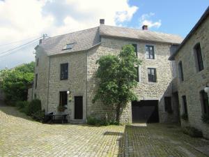 an old stone building with a tree in front of it at Alpine Getaway in Neustift in Treignes