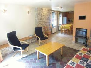 a living room with chairs and a table and a fireplace at Apartment near Forest and Hiking Trails in Treignes