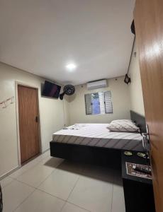 Un dormitorio pequeño con una cama y una ventana. en Hotel Oasis, en São Paulo