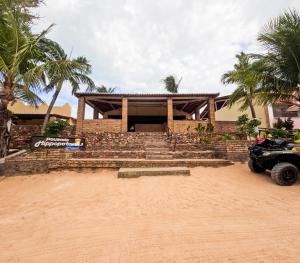 a house with a car parked in front of it at Pousada Hippopotamus Jeri in Jericoacoara