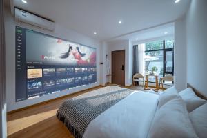 ein Schlafzimmer mit einem großen Bildschirm an der Wand in der Unterkunft 山也云也大理古城南门店 in Dali Ancient Town