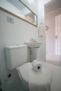 a white bathroom with a toilet and a sink at Pousada Hippopotamus Jeri in Jericoacoara