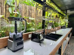a kitchen counter with a blender and a sink at Kalunay Hostel - Breakfast included in Puerto Viejo