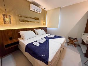 une chambre avec un grand lit avec une couverture bleue dans l'établissement Flat premium no Naay Villas Boutique para 8 pessoas, à Tatuamunha 40 autres photos