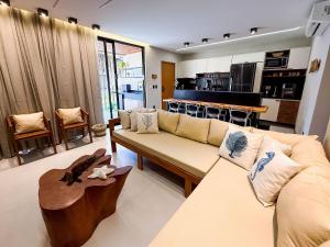 un salon avec un canapé et une table dans l'établissement Flat premium no Naay Villas Boutique para 8 pessoas, à Tatuamunha