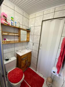 a bathroom with a red toilet and a sink at Igrejinha RS in Igrejinha