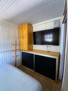 a room with a bed and a flat screen tv at Igrejinha RS in Igrejinha +5 photos