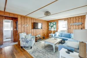 ein Wohnzimmer mit einem blauen Sofa und einem Tisch in der Unterkunft 1 Block to Humarock Beach Pet-Friendly Cottage in Fourth Cliff