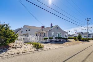 ein Haus mit einem weißen Zaun an der Straßenseite in der Unterkunft 1 Block to Humarock Beach Pet-Friendly Cottage in Fourth Cliff