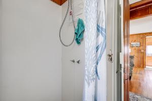 Zimmer mit einer Tür mit einem Duschvorhang in der Unterkunft 1 Block to Humarock Beach Pet-Friendly Cottage in Fourth Cliff + 17 Fotos