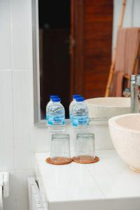 two bottles of water sitting on top of a bathroom counter at Kubu Kak Dudung Villas in Jimbaran