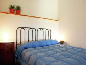 a bed in a bedroom with a blue bedspread at Romantic Stay Near Velia in Marina di Ascea