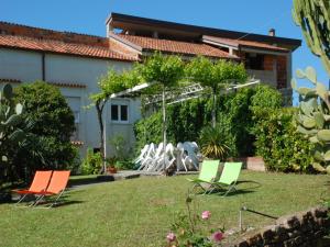 three chairs in a yard with a house at Romantic Stay Near Velia in Marina di Ascea