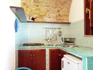 a kitchen with two sinks and a stone wall at Villa in Velia near Roman Ruins and Beach in Marina di Ascea