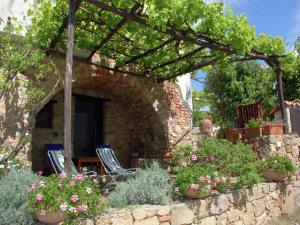 a stone house with two chairs and flowers at Villa in Velia near Roman Ruins and Beach in Marina di Ascea +14 photos