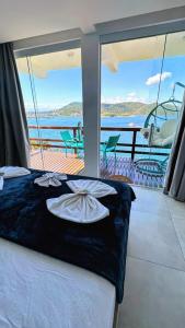 a bed on a yacht with a view of the water at Pousada Vista Grega in Arraial do Cabo