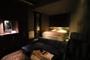 a living room with a bed and a couch at ホテルロンシャンーAdult onlyー 
