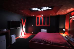 a red room with a bed and a tv at ホテルロンシャンーAdult onlyー 