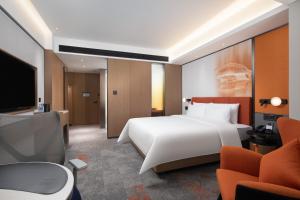 a hotel room with a bed and a tv at 海口国贸希尔顿欢朋酒店 in Haikou +17 photos