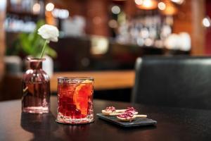 a table with a drink and a vase with a flower at Starhotels Ritz in Milan