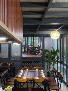 a dining room with a large wooden table and chairs at Homestay Đồi Mây Lộc Tân Bảo Lộc in Bảo Lâm