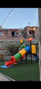 a playground with a colorful slide in a yard at عزبة وادي السدر in ‘Ashashah