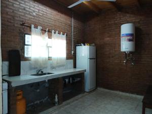 a kitchen with a sink and a refrigerator and a window at Finca La Huella II in Santiago del Estero