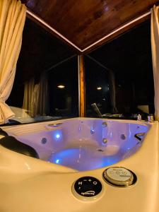 a blue bath tub in a room with a window at Pousada Invernada in São Joaquim