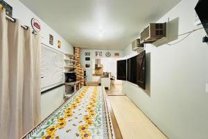 a hallway with a yellow and green rug on the floor at Quintal do Beto Carreiro/450m praia+wifi+ArCondici in São Lídio +6 photos