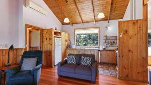 a living room with two chairs and a kitchen at Halcyon - Peaceful Family Retreat in Nungurner