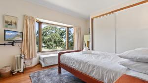 a bedroom with a bed and a large window at Halcyon - Peaceful Family Retreat in Nungurner