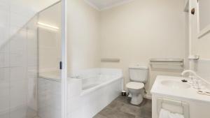 a white bathroom with a tub and a toilet and a sink at Halcyon - Peaceful Family Retreat in Nungurner +6 photos