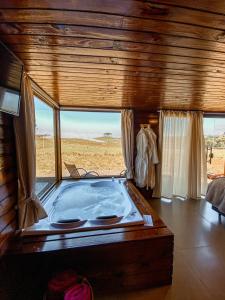 a large hot tub in a room with a window at Pousada Invernada in São Joaquim