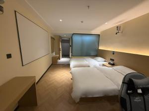 a hotel room with two beds and a blank screen at Hulk Esports Cinema Hotel Guiyang Fountain Pool Branch in Guiyang