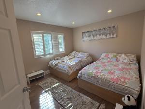 a bedroom with two beds and a window at South OC House in Laguna Niguel