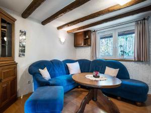 a living room with a blue couch and a table at Ferienwohnung, Oberkirchen in Schmallenberg