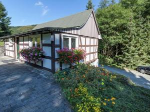 a small house with flowers in front of it at Ferienwohnung, Oberkirchen in Schmallenberg